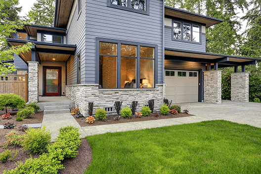 Luxurious Home Design With Modern Curb Appeal In Bellevue. Luxurious new home with curb appeal. Trendy grey two-story exterior in Bellevue with large picture windows stone foundation veneer covered porch and concrete pathway. Northwest USA
